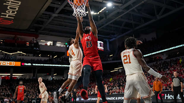 Cincinnati Bearcats forward Jamille Reynolds (13) dunks over Texas Longhorns guard Tyrese Hunter (4) in the first half of the NCAA Big 12 basketball game between the Cincinnati Bearcats and the Texas Longhorns at Fifth Third Arena in Cincinnati on Tuesday, Jan. 9, 2024.